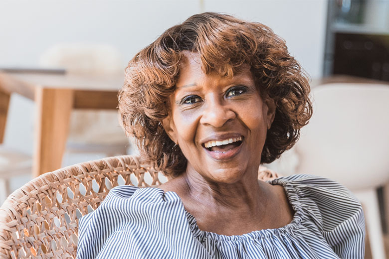 Smiling elderly woman sitting outside